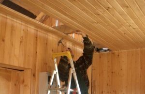 Мужчина укладывает потолок